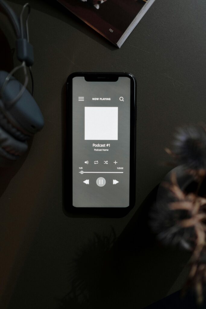 A vertical shot of a smartphone displaying a podcast interface on a dark surface.
